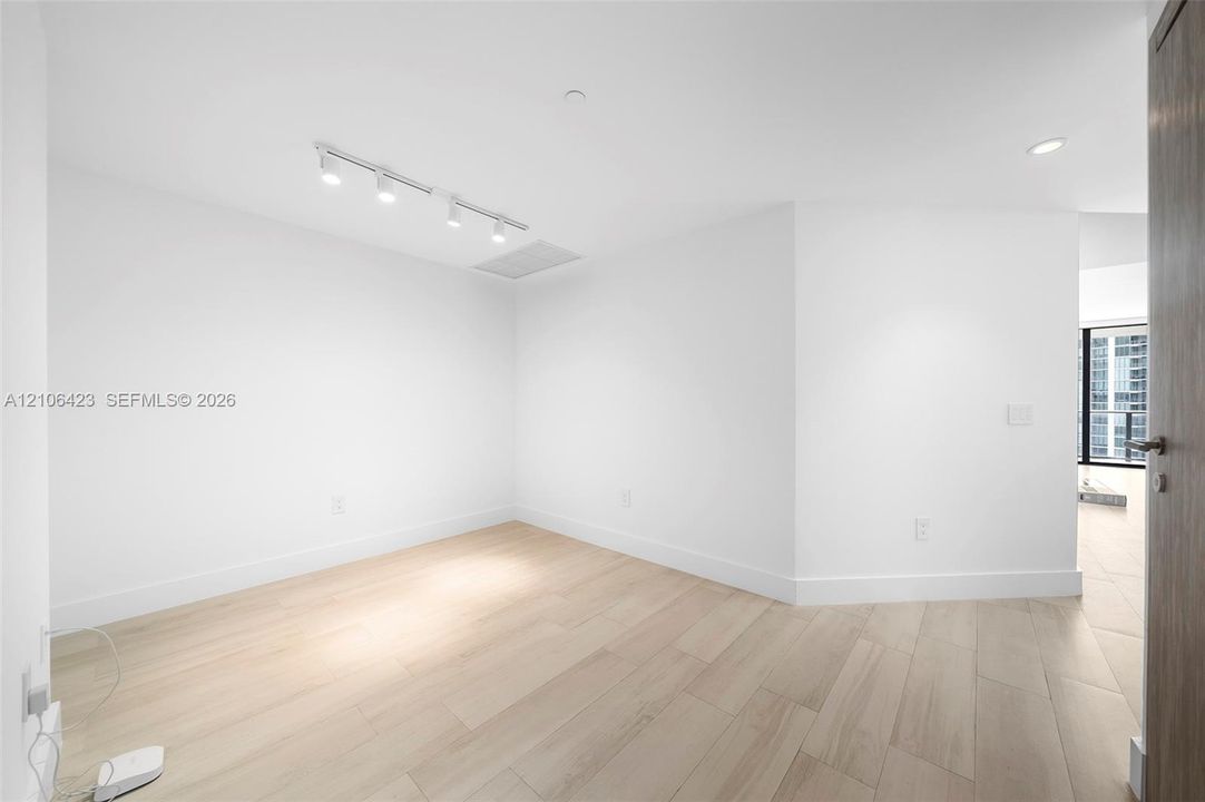 Interior space featuring light wood-finish flooring, recessed lighting, and adjustable track lighting