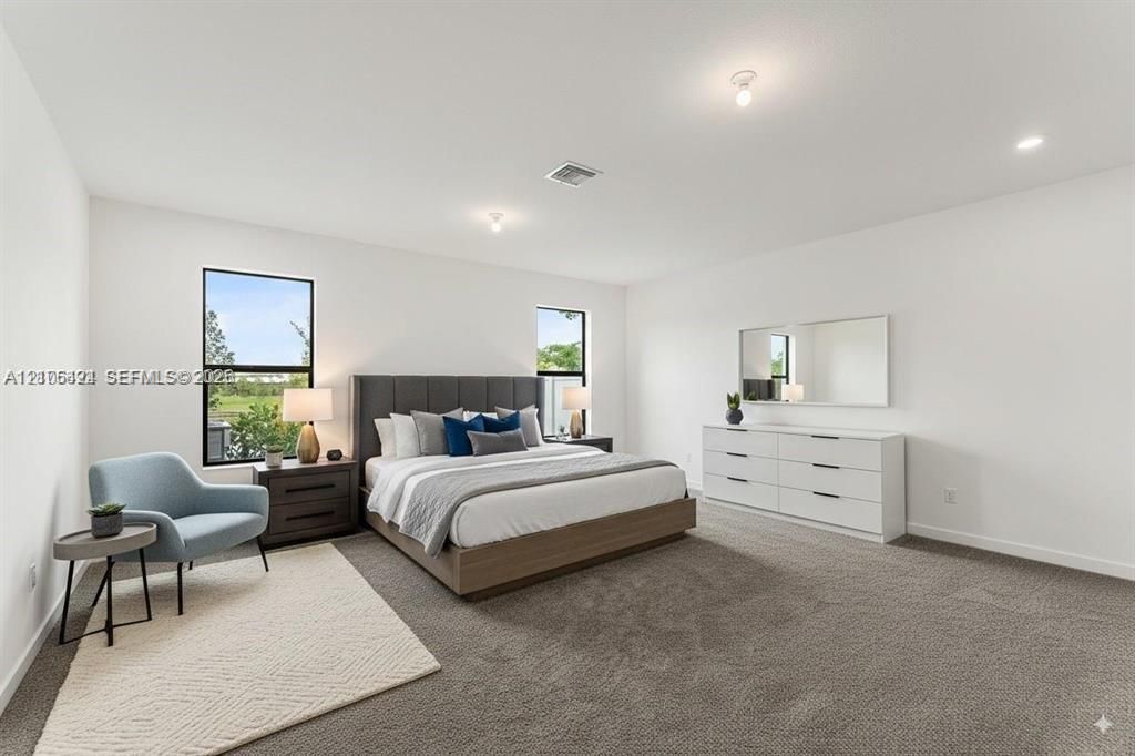Spacious room featuring neutral carpeting, high ceilings with recessed lighting, and large windows with exterior views