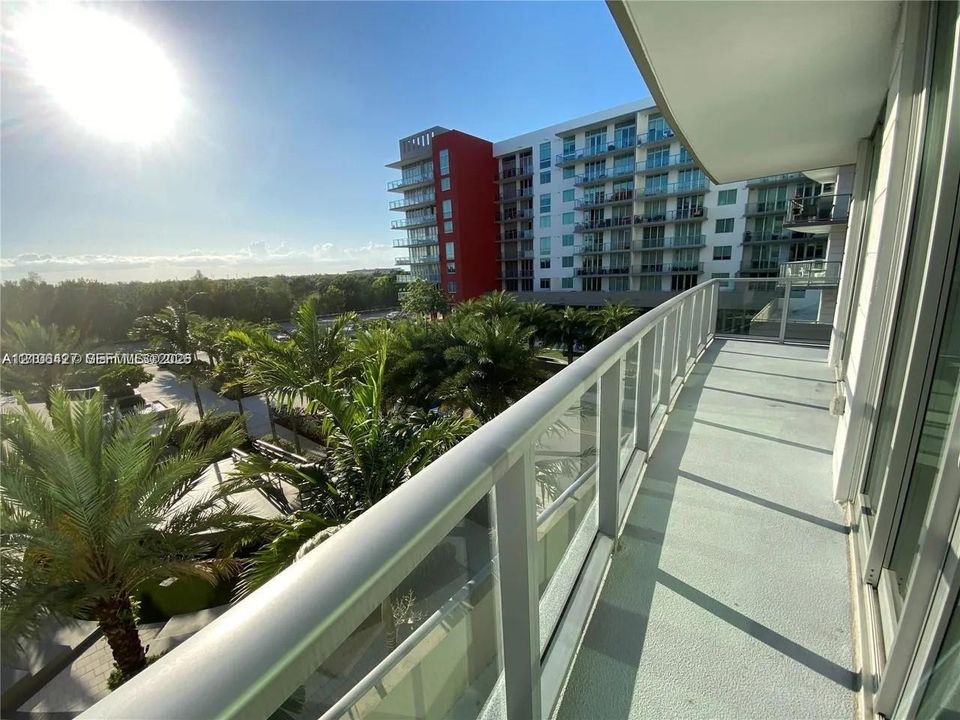 Private balcony featuring concrete flooring and glass-paneled metal railings