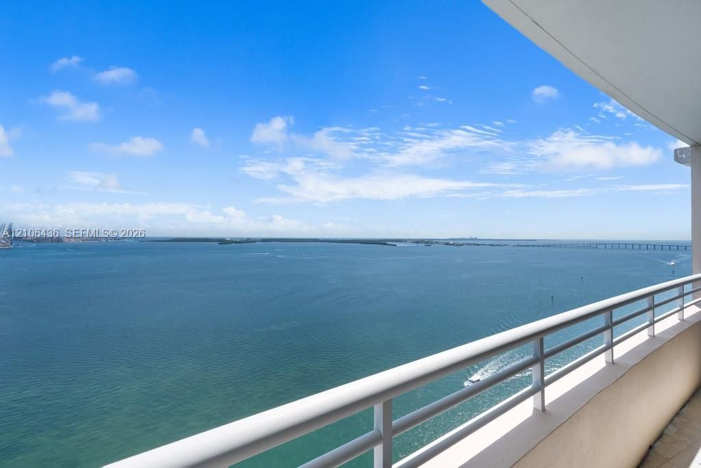 Private balcony featuring white metal railings and expansive water scenery