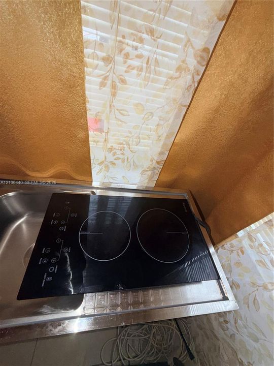 Two-burner glass-ceramic induction cooktop featuring a sleek black finish and integrated touch-control interface