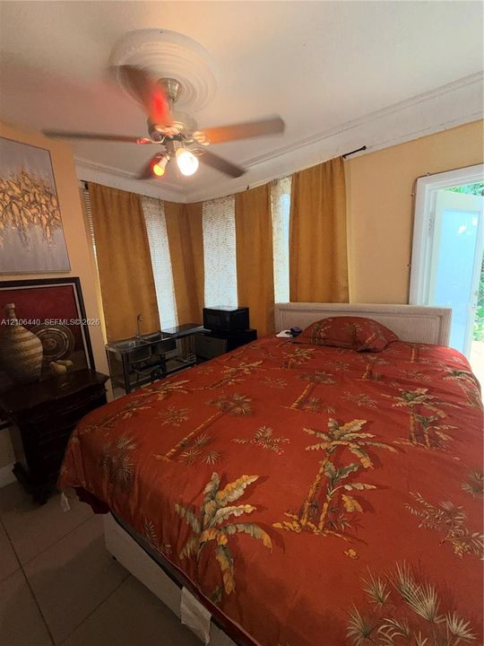 Ceiling fan with central medallion, multi-panel windows, crown molding, and tiled flooring