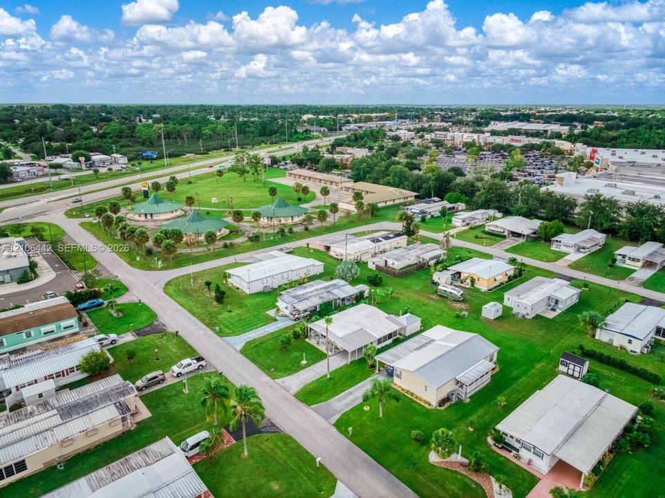 Aerial view of this manufactured home community featuring individual lots with mature landscaping, wide streets, and abundant green space