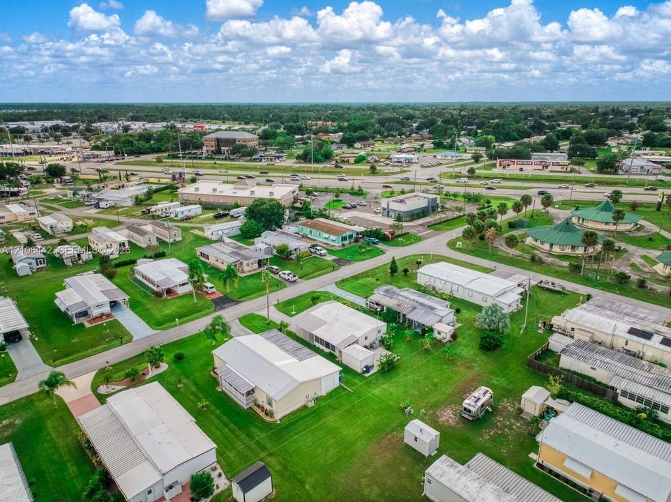 Aerial perspective of a residential community featuring paved streets, landscaped grass lots, and dispersed housing structures