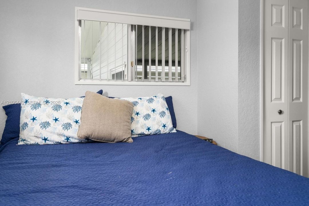 Horizontal sliding window with integrated vertical blinds and white paneled bifold closet door