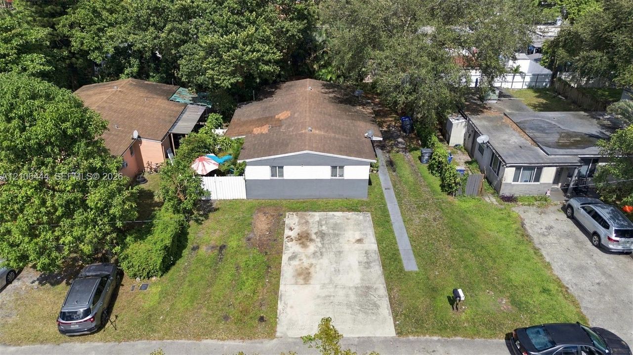 Single-story structure with a two-tone exterior, asphalt shingle roofing, and a dedicated concrete parking pad
