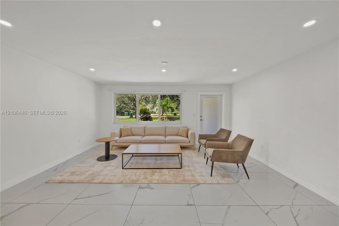 Large-format tile flooring with veining, recessed lighting, and a multi-pane window
