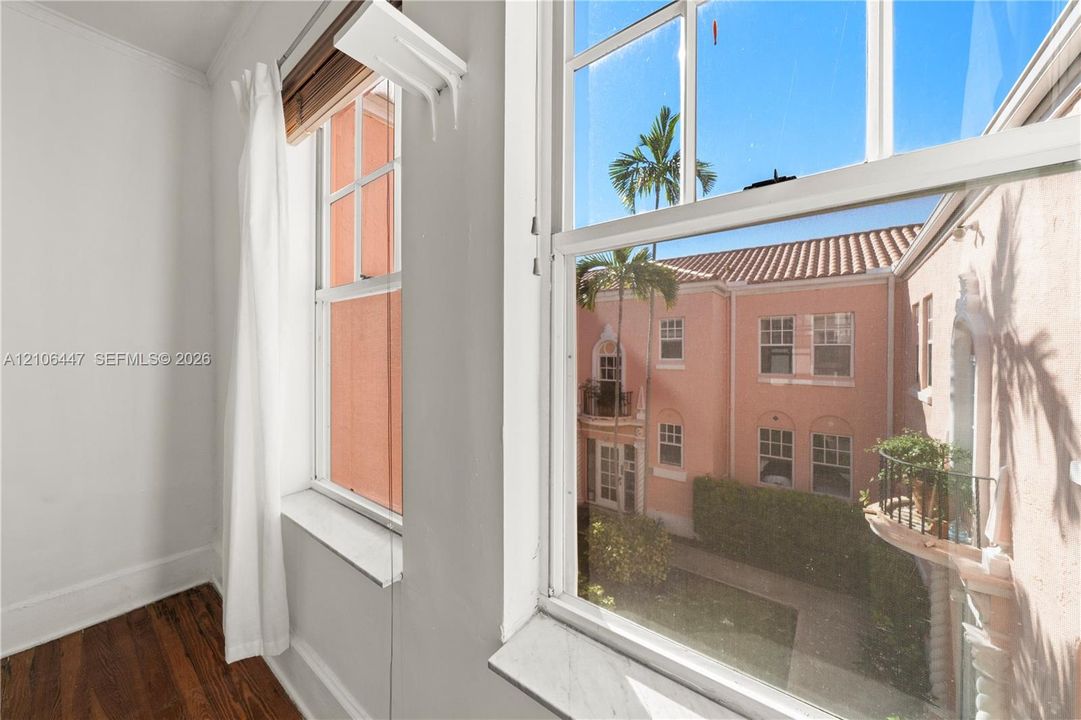 Multi-pane sash windows featuring stone sills and wood-finish flooring