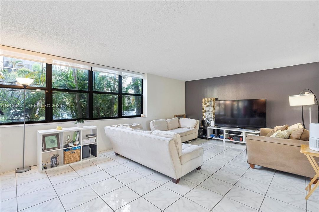 Large-format window assembly with black framing, polished tile flooring, and a decorative accent wall