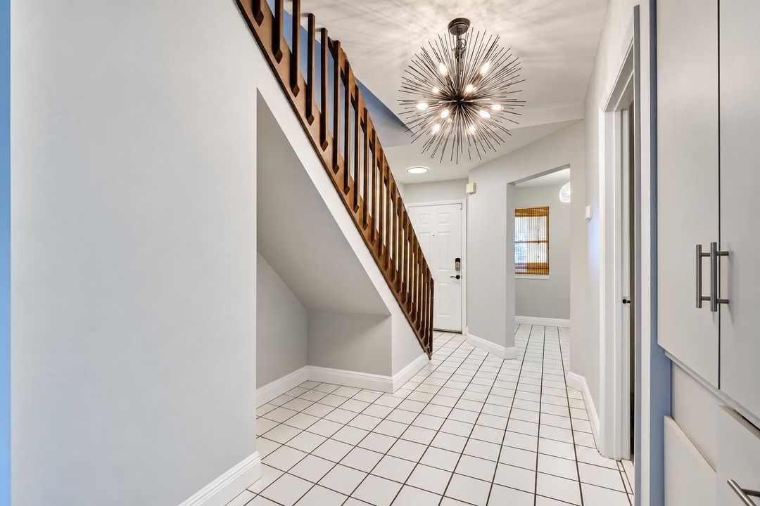 Unfurnished tiled entryway with staircas