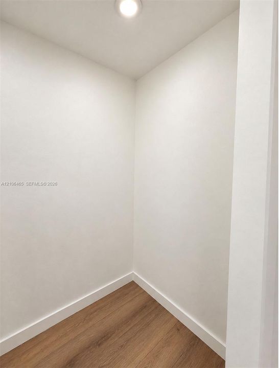 Neutral-toned interior space featuring wood-finish flooring and flush-mount ceiling lighting