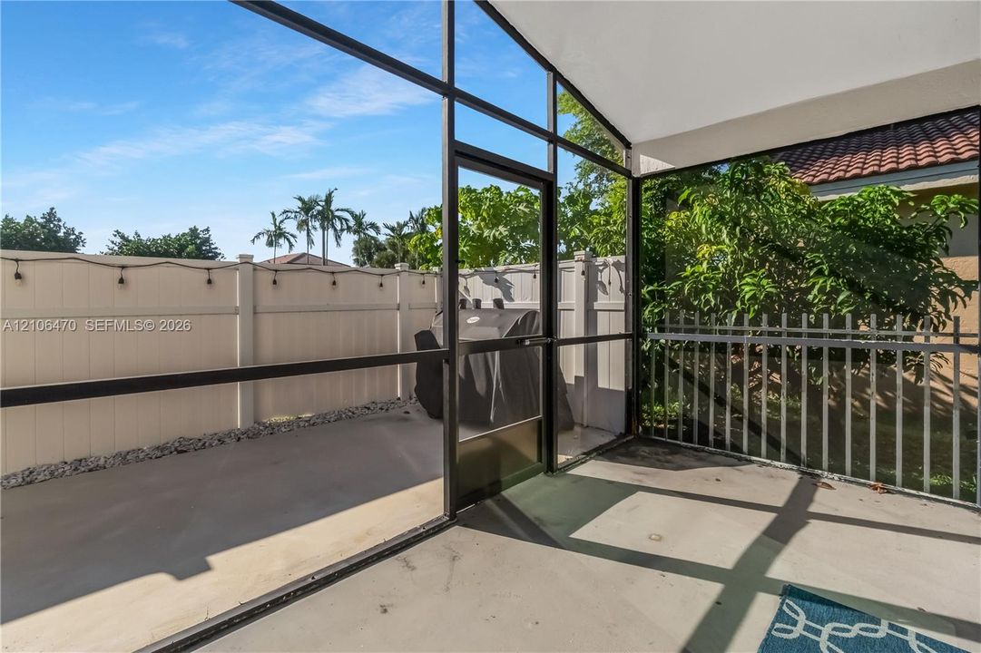 Screen-enclosed patio with a concrete floor, high-pitched ceiling, and privacy fencing
