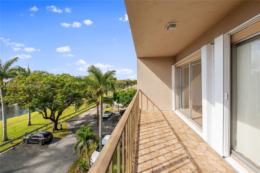 Covered balcony featuring tiled flooring, metal railing, and sliding glass door entry