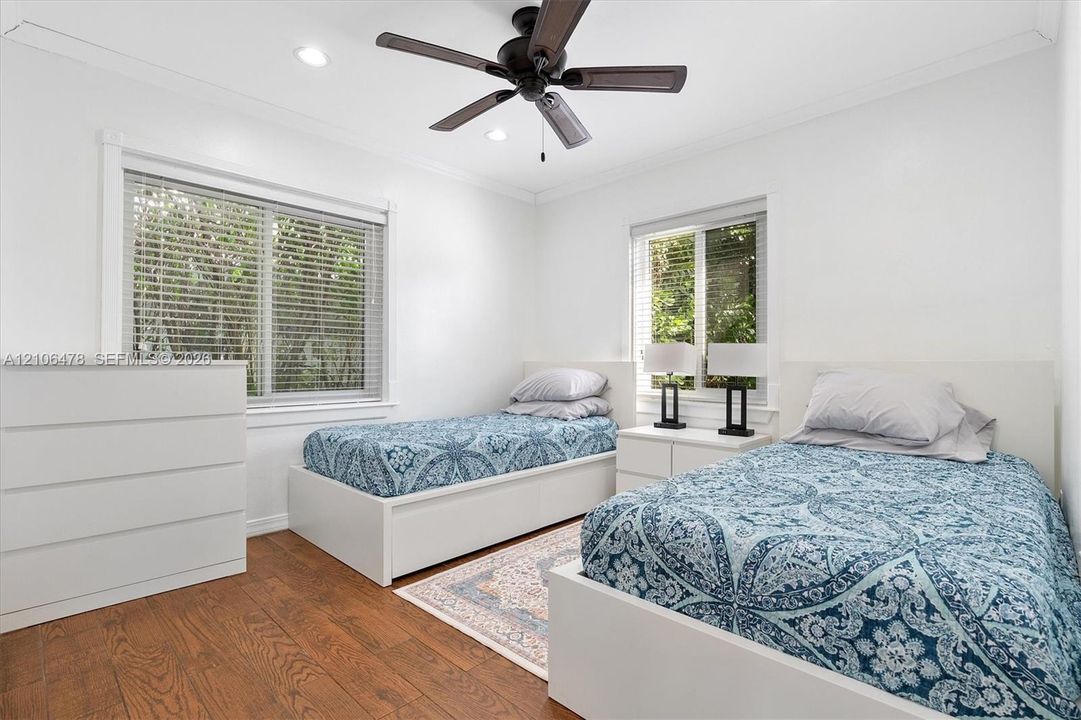 Bedroom featuring wood-finish flooring, recessed lighting, a ceiling fan, and dual windows