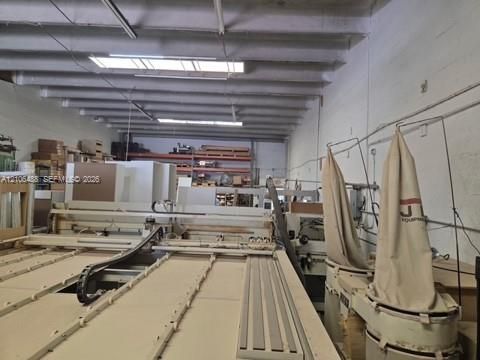 Industrial workspace featuring high, exposed-beam ceilings, integrated dust collection systems, and open-span floor plan