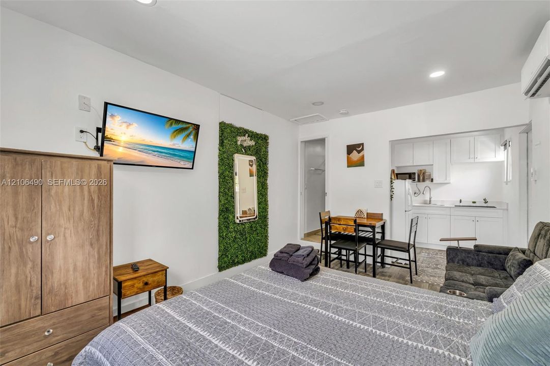 Kitchenette featuring white cabinetry, recessed lighting, and wall-mounted air conditioning unit