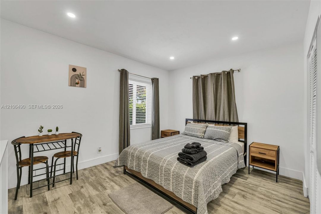 Neutral interior space featuring wood-finish flooring, recessed lighting, and louvered closet doors