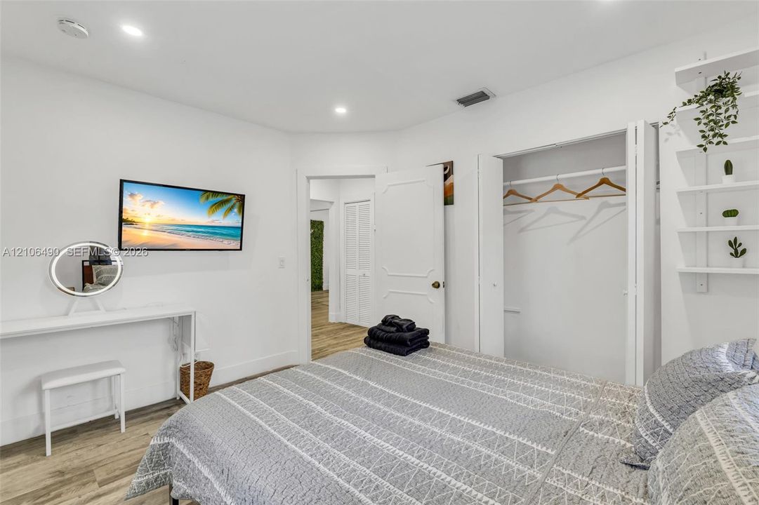 Wood-finish flooring, recessed lighting, built-in shelving, and dual-panel interior doors