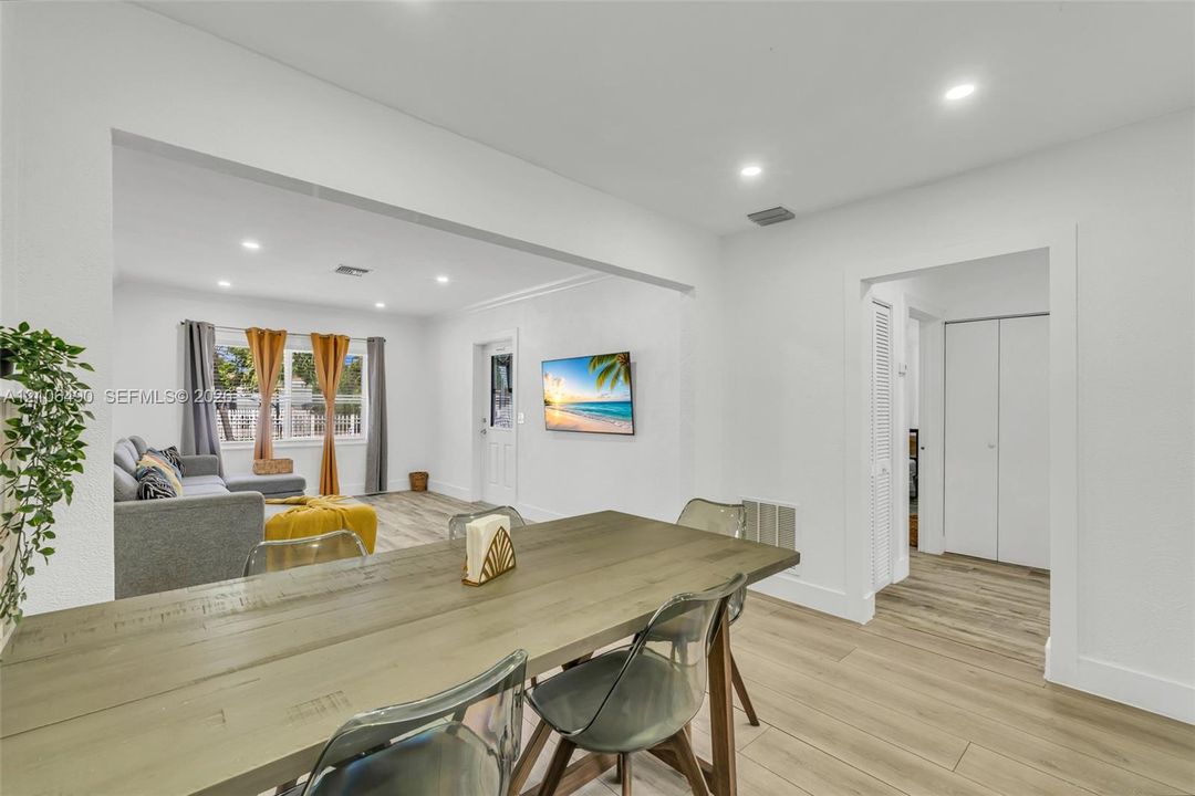 Open-concept interior featuring light-toned wood-finish flooring, recessed ceiling lighting, and crisp white wall finishes