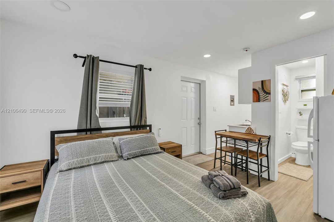 Neutral-toned interior featuring wood-finish flooring, recessed lighting, and a window with a curtain rod fixture