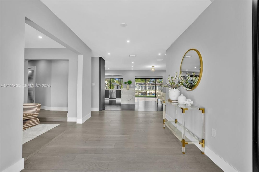 Open floor plan featuring wood-finish flooring, recessed lighting, and large sliding glass doors