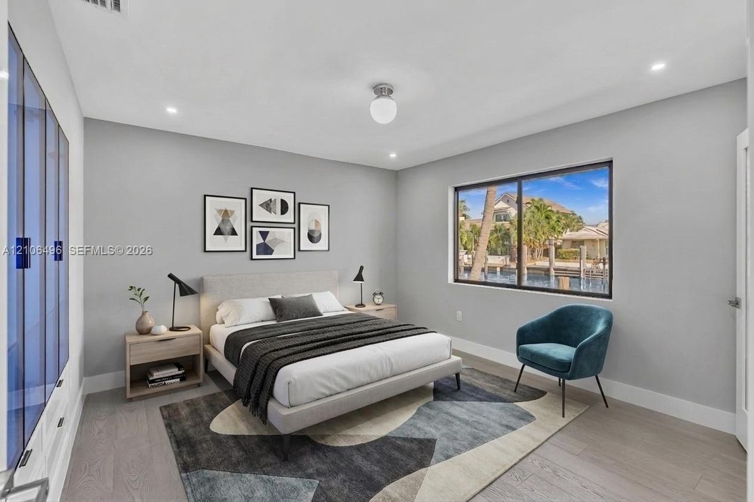 Neutral-toned walls, wood-finish flooring, built-in blue glass-front cabinetry, a large picture window, and recessed ceiling lighting