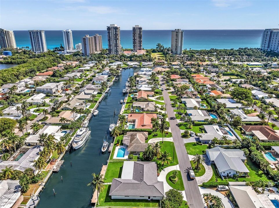 Aerial perspective of a coastal residential community featuring deep-water canal access, private boat docks, and established landscaping