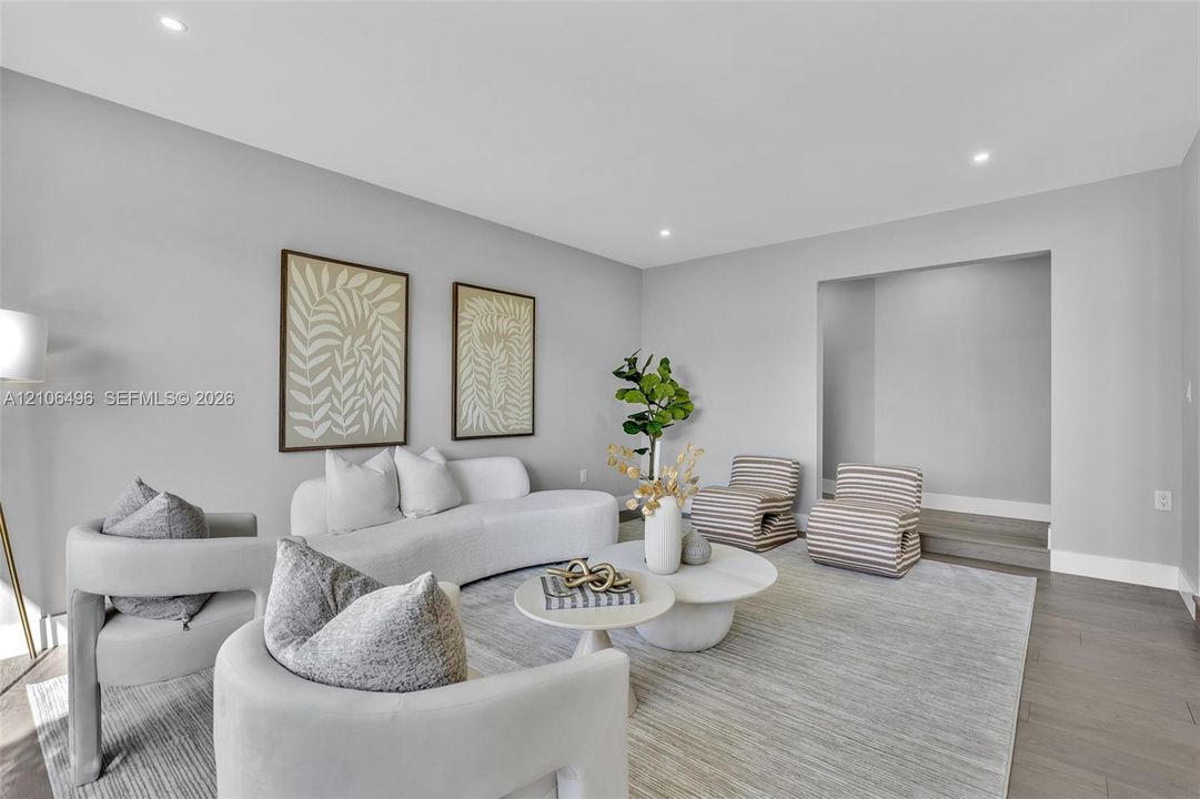 Living area featuring wood-finish flooring, recessed lighting, and a recessed architectural alcove