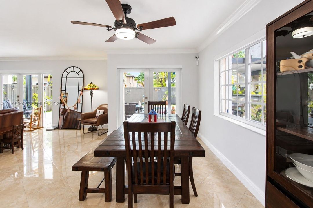 Large-format polished tile flooring, multi-pane windows, and a ceiling-mounted light fixture with a fan