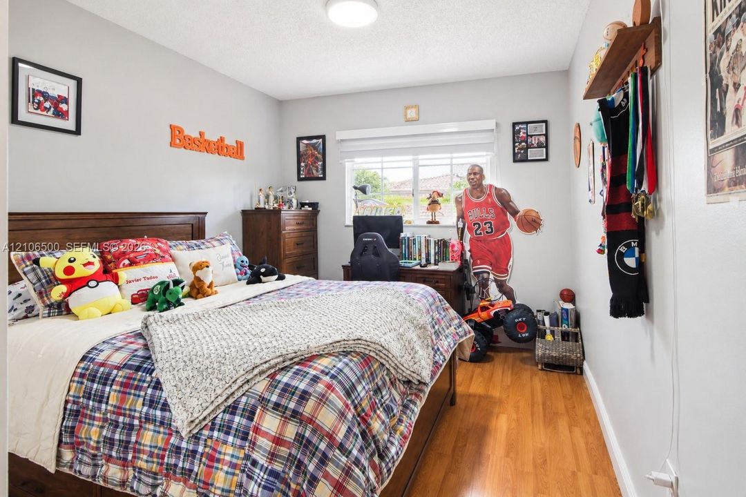 Wood-finish flooring, dual-pane window with roller shade, and ceiling-mounted light fixture