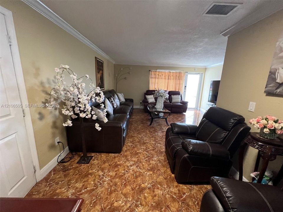 Polished stone-finish tile flooring, multi-panel interior door, and glass-paneled exterior door featuring integrated blinds