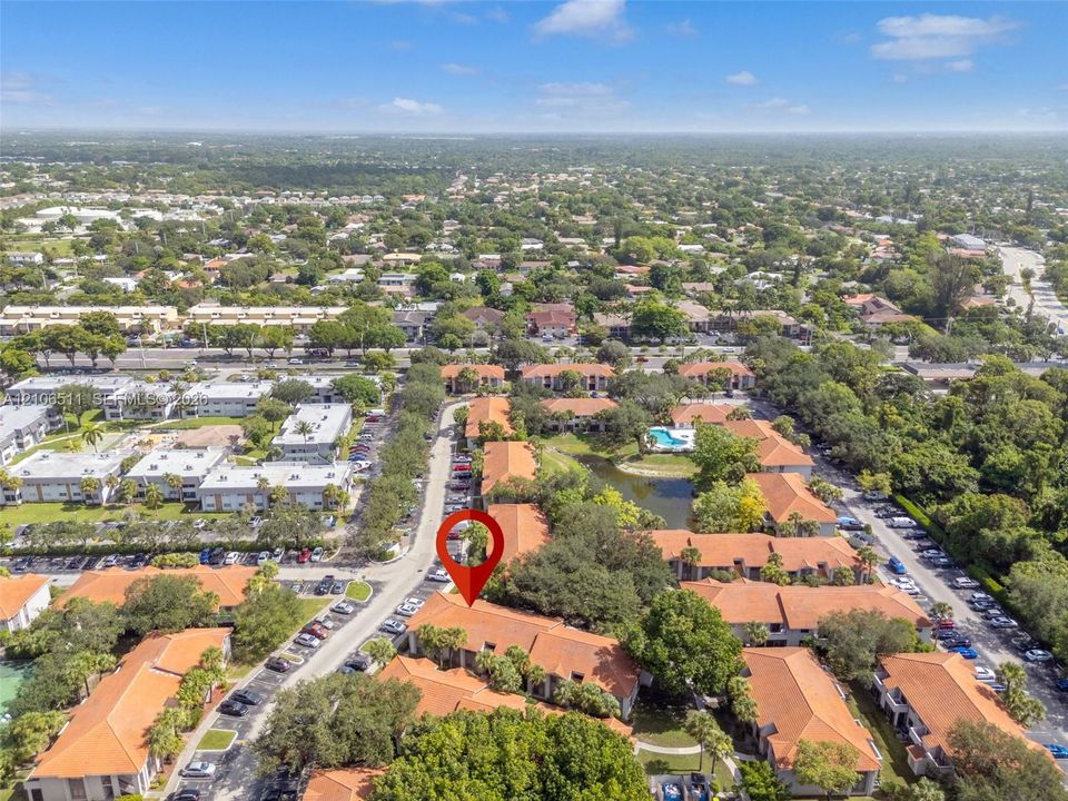Aerial view of residential community featuring terra-cotta tile rooflines, mature canopy trees, and an established landscaping layout