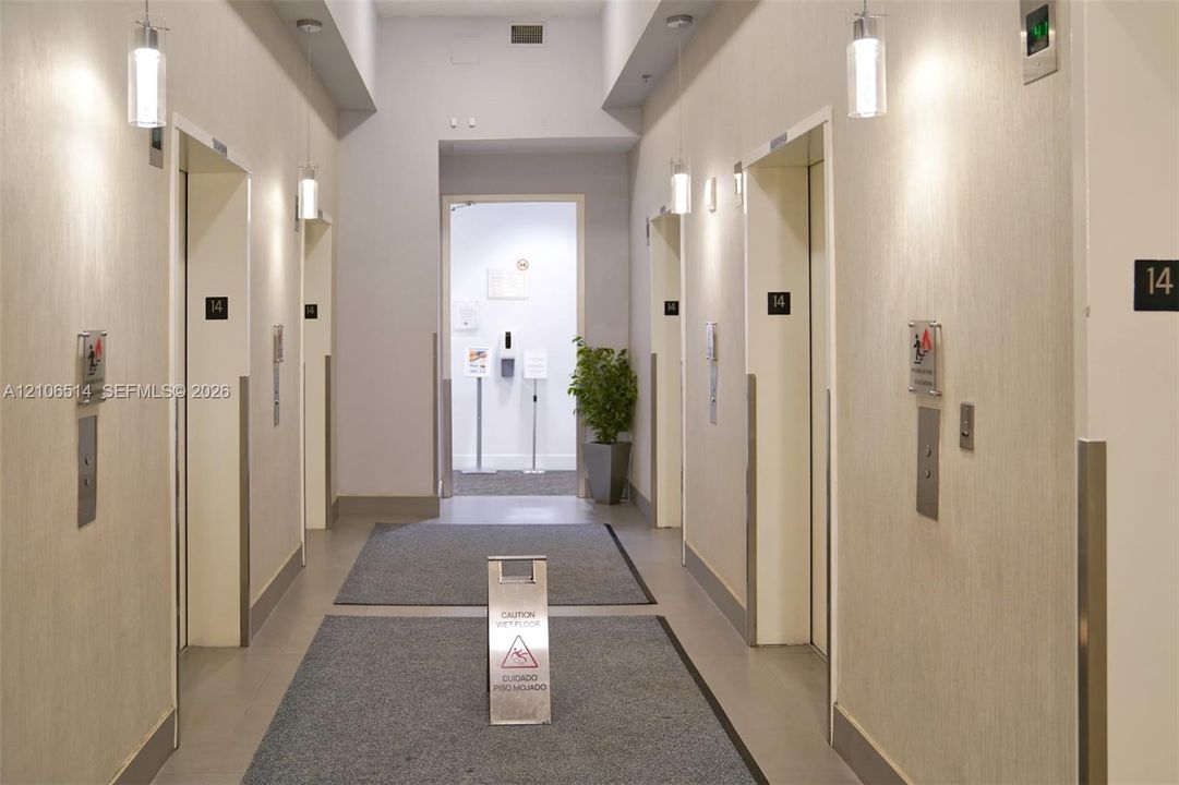 Elevator lobby featuring metallic call buttons, recessed lighting, and neutral-toned wall surfaces