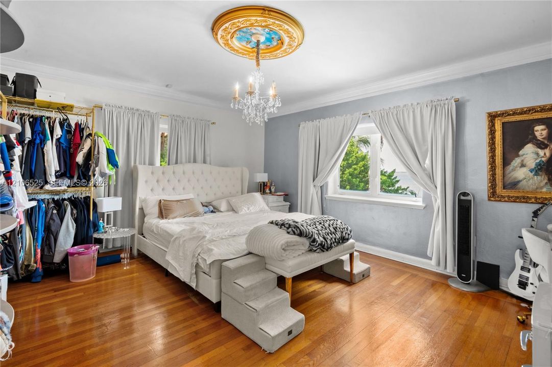 Hardwood flooring, decorative ceiling medallion, and crystal chandelier fixture