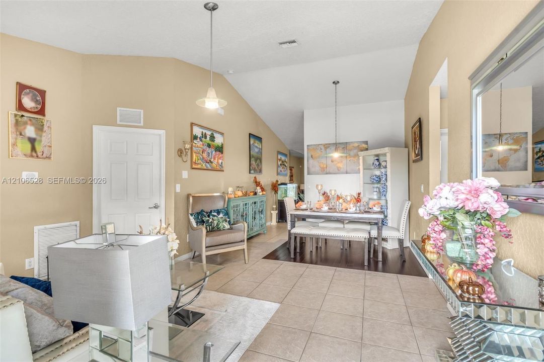 Vaulted ceilings, large-format tile flooring, dual pendant lighting fixtures, and recessed wall niches