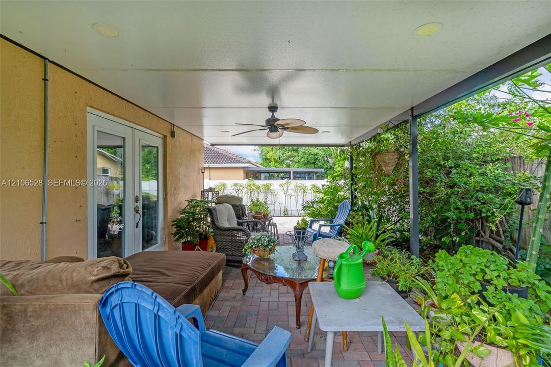 Covered patio featuring a paved brick floor, recessed ceiling lighting, a ceiling fan, and French glass entry doors