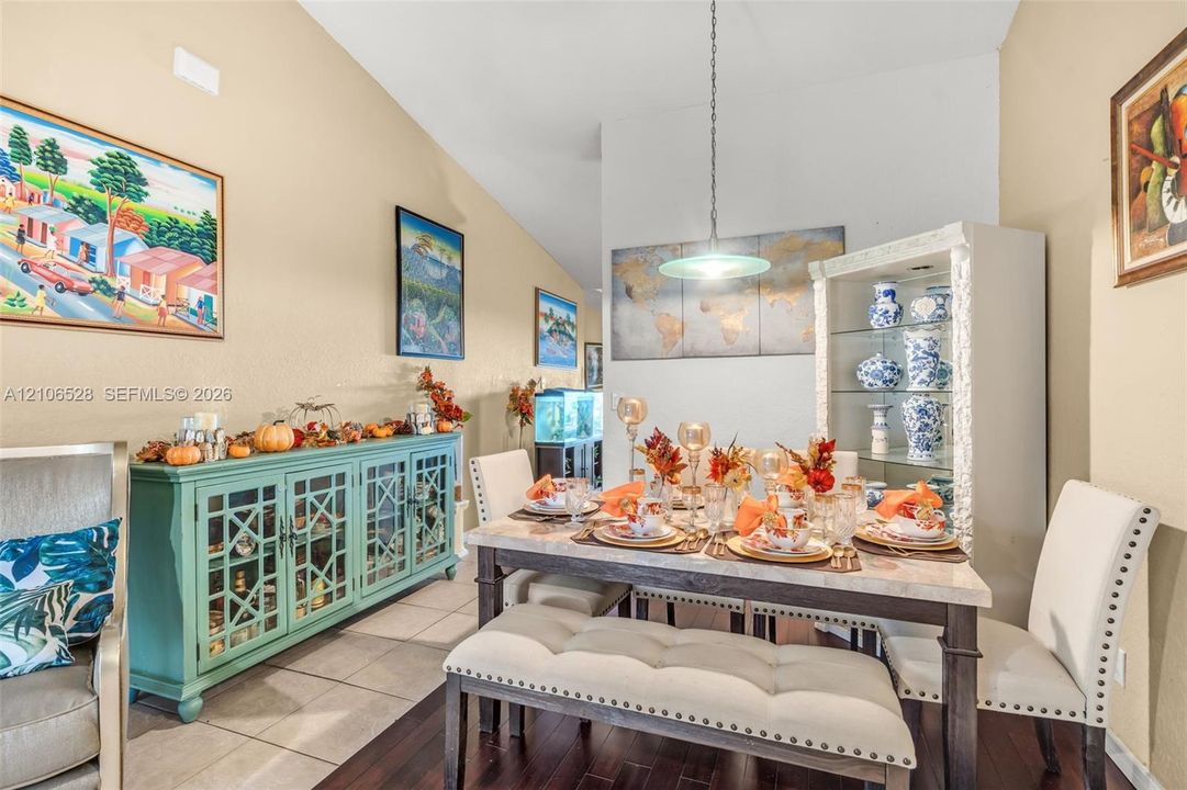 Vaulted ceiling, decorative pendant light fixture, and tile flooring