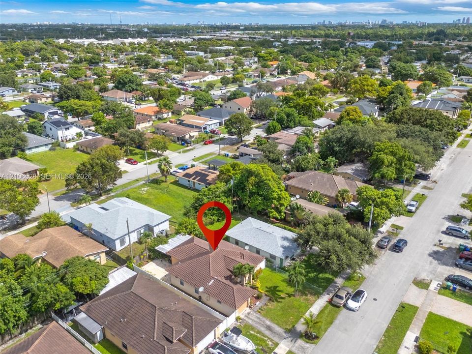 Aerial view of a residential lot featuring a concrete tile roof, attached garage, and paved driveway