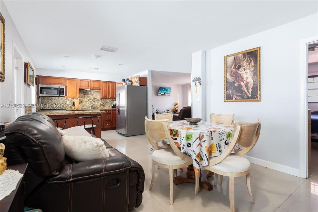 Kitchen featuring wood cabinetry, stone-finish countertops, stainless steel refrigerator, and recessed lighting