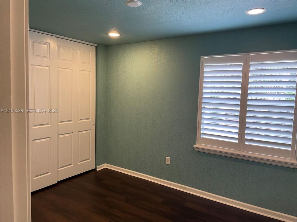 Interior space featuring wood-finish flooring, recessed lighting, and a double-door closet with paneled detailing