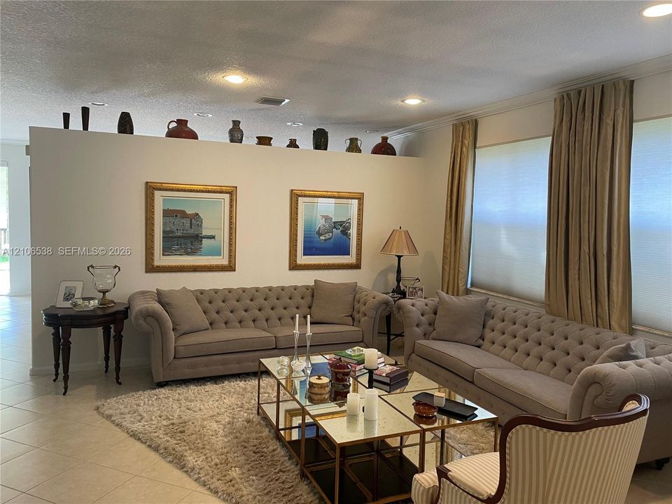 Partition wall with decorative display ledge, recessed ceiling lighting, and large-format tile flooring
