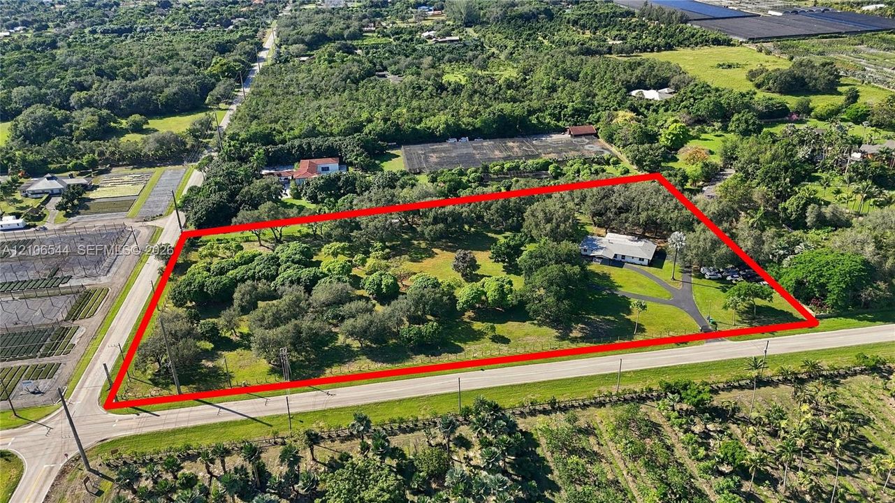 Expansive parcel featuring mature oak trees, paved driveway, and established landscape