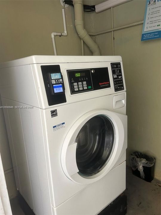 Commercial-grade front-loading washing machine with a digital control interface and integrated payment system