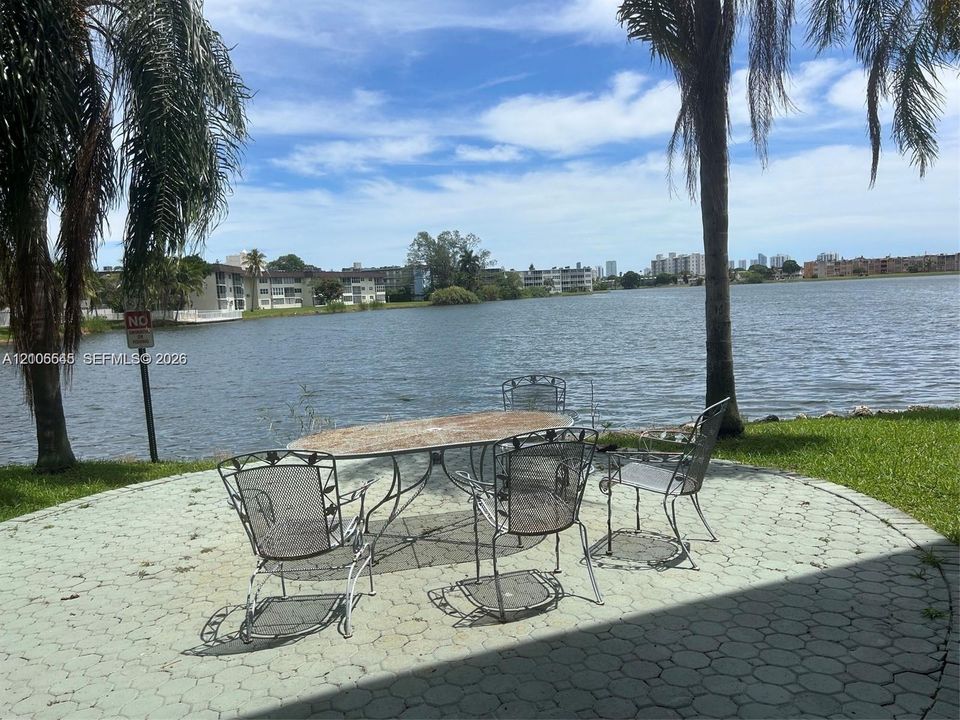 Circular paver patio featuring expansive water frontage and mature palm trees