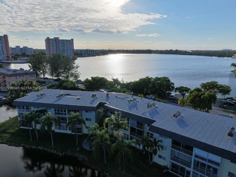 Multi-story residential building featuring a low-slope roof, screened balconies, and waterfront positioning