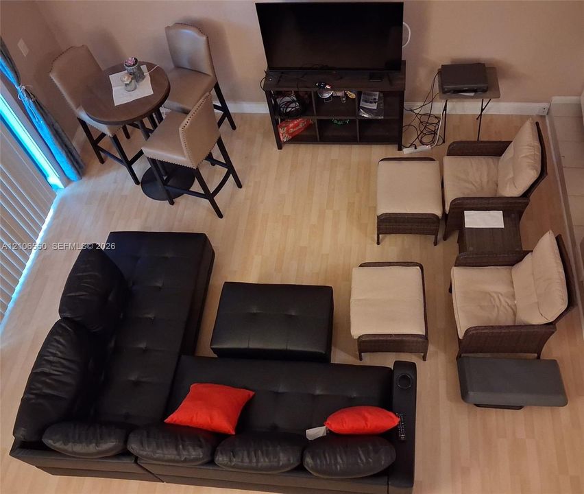 Open-concept interior featuring light wood-finish flooring and vertical window blinds