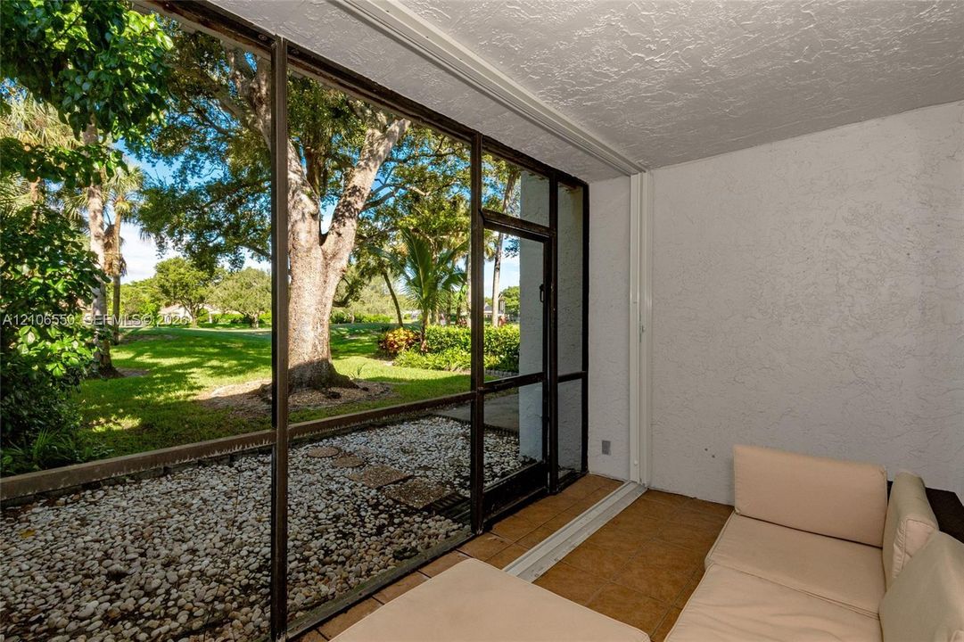 Screened-in patio featuring textured walls, tile flooring, and metal-framed screen enclosures