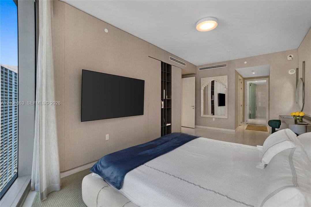 Floor-to-ceiling windows, wall-to-wall integrated paneling, built-in vertical shelving, recessed lighting, and mirrored wall accents
