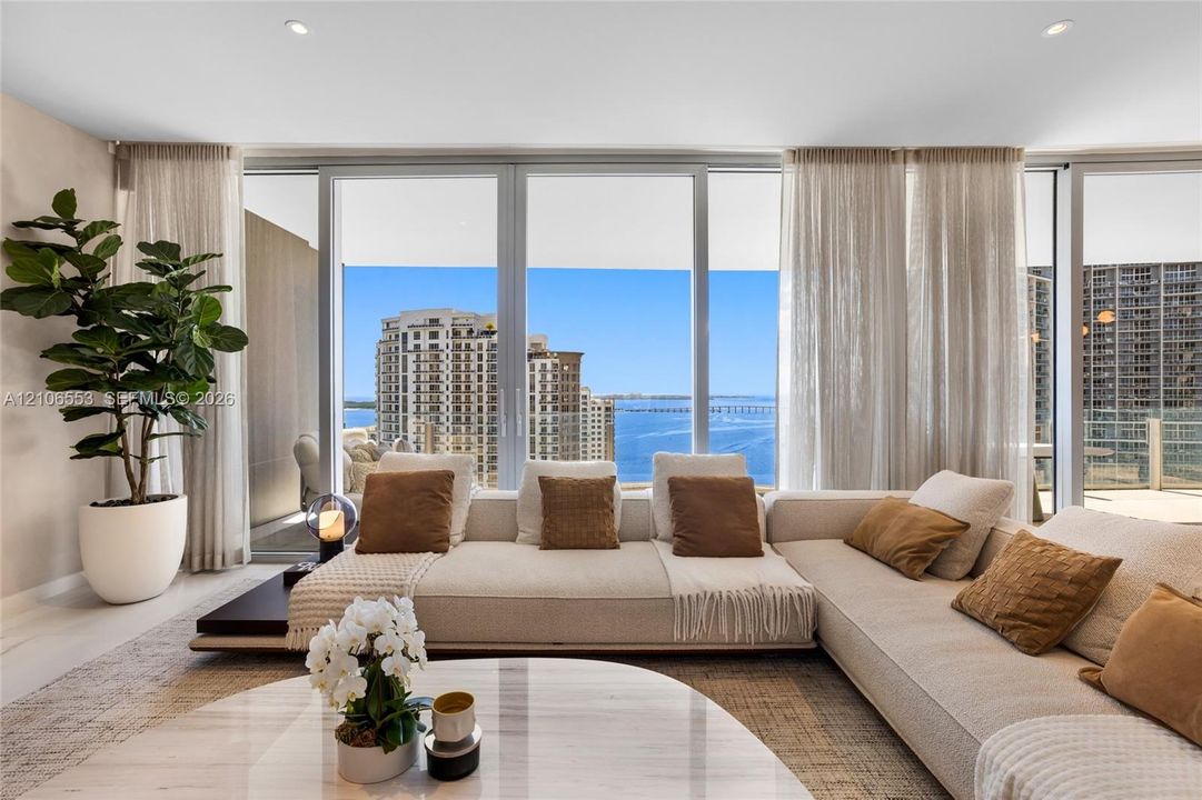 Floor-to-ceiling glass windows, recessed lighting, and neutral wall tones