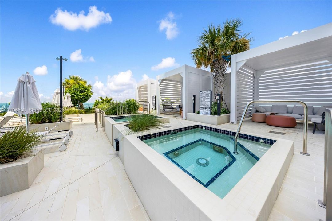 Rooftop terrace featuring built-in spa with tile surround, white pergolas, stone-finish decking, and integrated landscaping planters